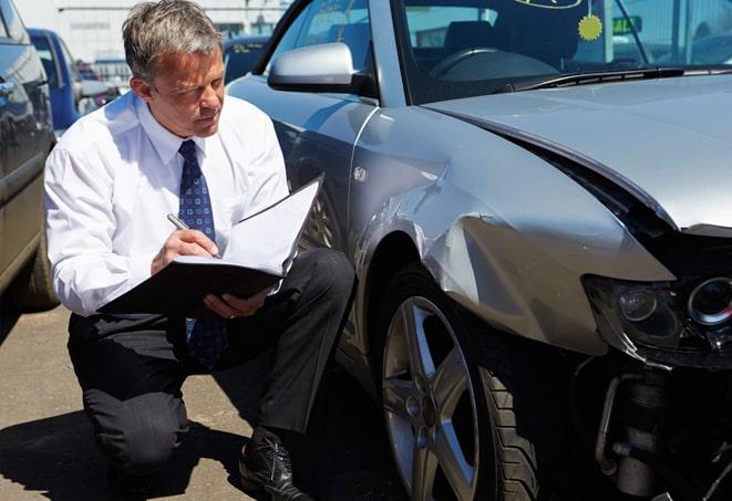 green car parked with insurance information displayed on windshield